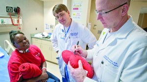 Dr. Alan Simeone signs a heart shaped pillow for Mackey as Dr. Matthew deShazo looks on.