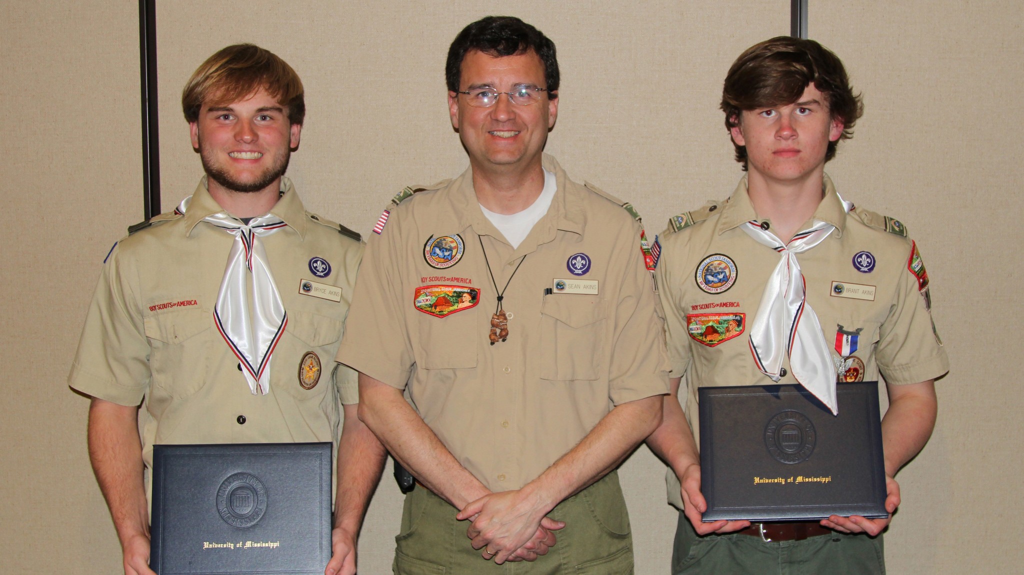 Brothers Bryce Akins (left) and Brant Akins (right), accompanied by their father and scoutmaster, Sean Akins, show off their Eagle Scout scholarship awards from the University of Misissippi at the Yocona Area Council's recent Youth Recognition Banquet. The Ripley natives, members of Troop 38, both plan to attend Ole Miss. Photo by Mitchell Diggs