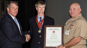 UM graduate Kerry Commander, (center), is presented with the National Defense Industrial Association Bronze Medal for achievements in Science and Technology. Photo courtesy of the U.S. Navy.
