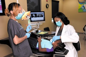 Minor, right, receives assistance from Kara Lindsey in Minor’s Pearl clinic, Smile Design Orthodontics.