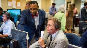 E.J. Jackson, project center manager for the UM Call Center, helps Chancellor Jeffrey S. Vitter navigate the system as he begins to make calls, personally thanking donors for their recent contributions. Photo by Bill Dabney