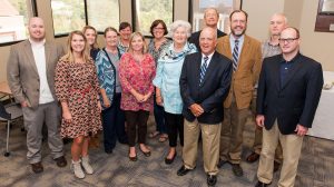 Reba Greer (center, in blue) and her husband, Lance (front, to her left), attend a reception in their honor hosted by faculty and staff of the UM Department of Writing and Rhetoric, for which the Greers established an endowment. Photo by Bill Dabney