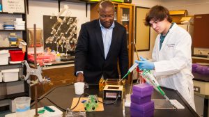 Murrell Godfrey (left), UM director of forensic chemistry, talks Embry scholar Lane Killough through the beginning stages of running a polymerase chain reaction. Forensic chemists use the PCR process to duplicate DNA until the sample size is large enough to analyze. Photo by Bill Dabney
