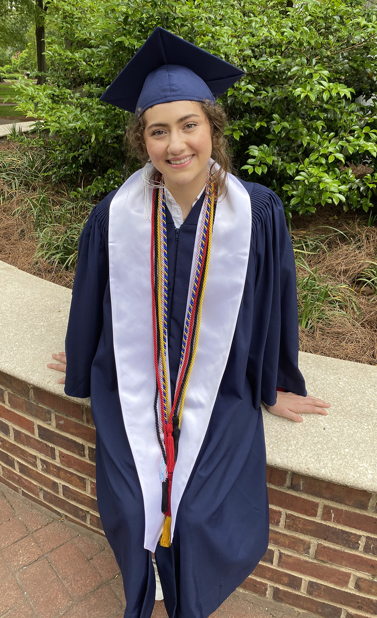 Brigitte Lewis in graduation cap and gown and cords