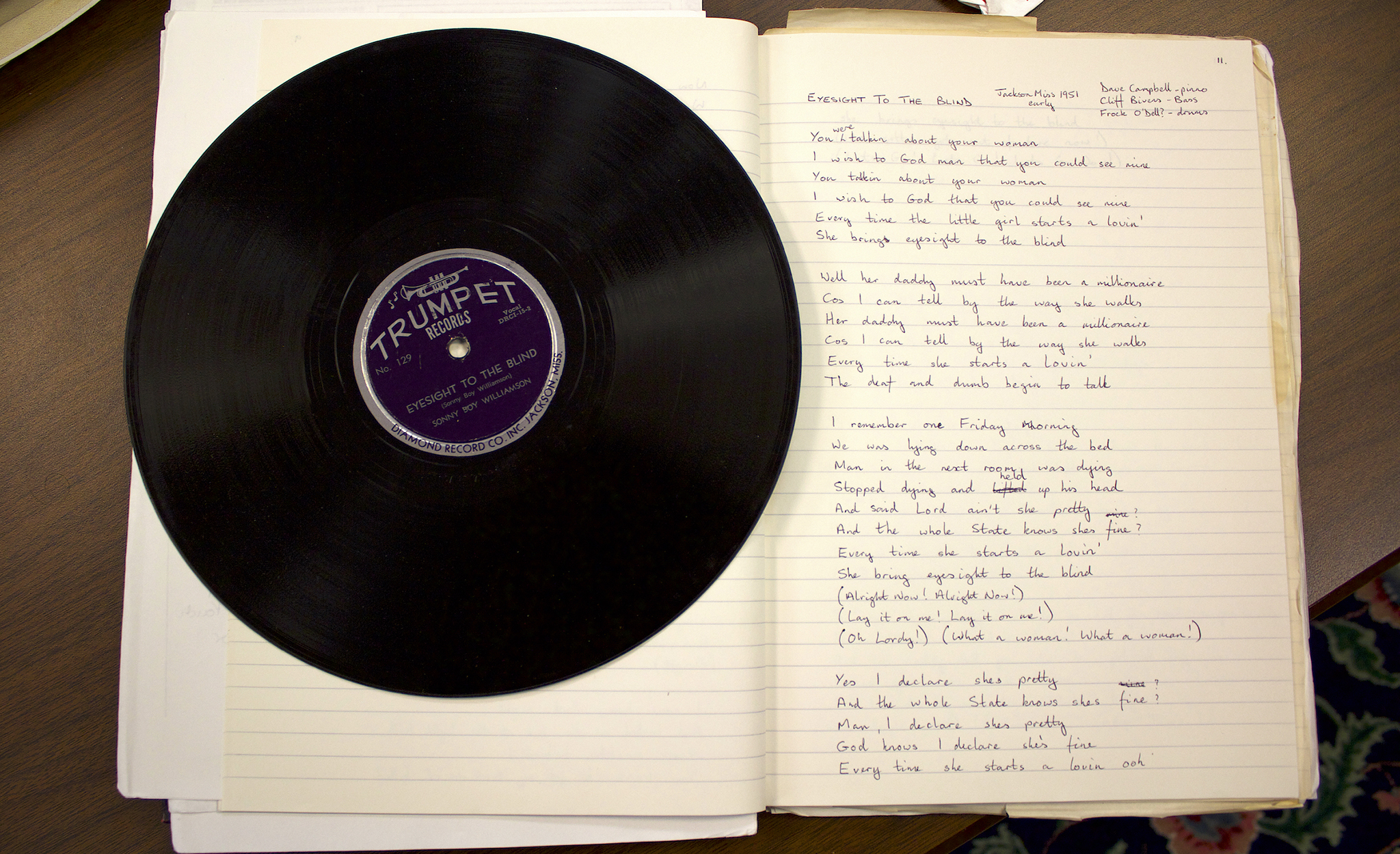 Bill Donaghue's vinyl record sitting on a notebook with song lyrics hand written