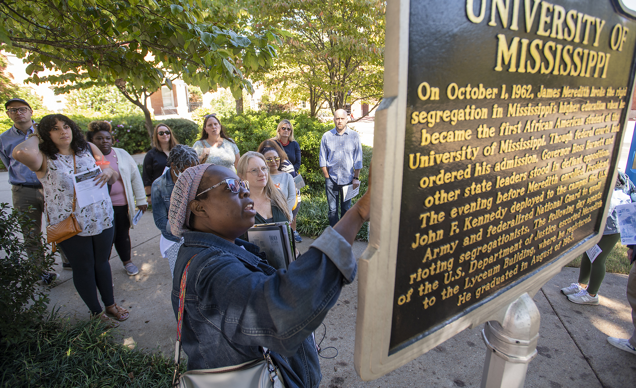 Rhondalyn Peairs (front), tour speaker and founder of Historich, an educational tourism company that organized the Civil Rights in Oxford Town bus tour, speaks about the Freedom Trail Marker on the UM campus during a tour. Photo by Thomas Graning/Ole Miss Digital Imaging Services