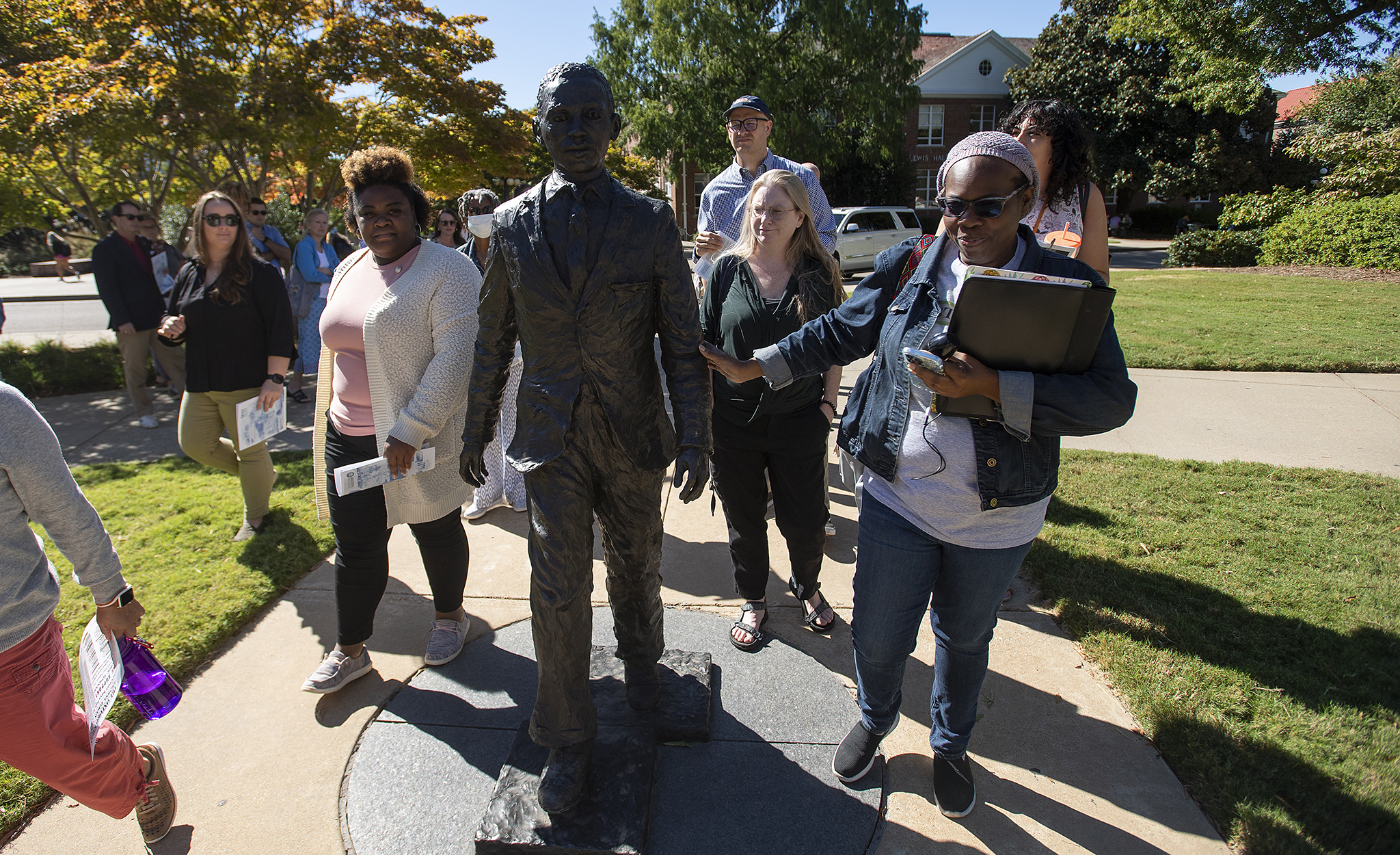 Rhondalyn Peairs (right) touches the statue of James Meredith near the Lyceum during a tour. Photo by Thomas Graning/Ole Miss Digital Imaging Services
