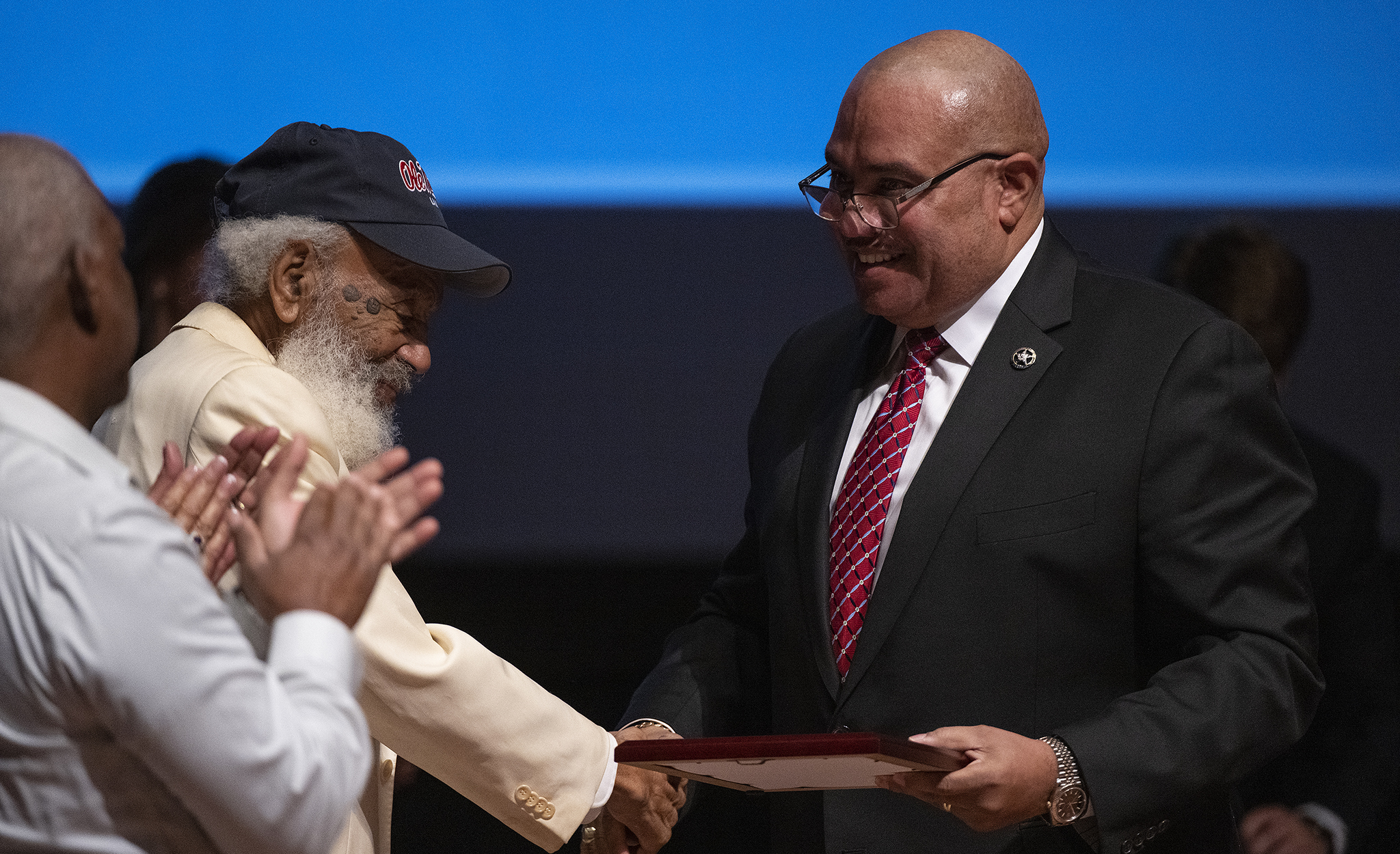Ronald L. Davis (right), director of the U.S. Marshals Service, presents James Meredith with a plaque honoring the civil rights leader as an honorary deputy. Photo by Thomas Graning/Ole Miss Digital Imaging Services