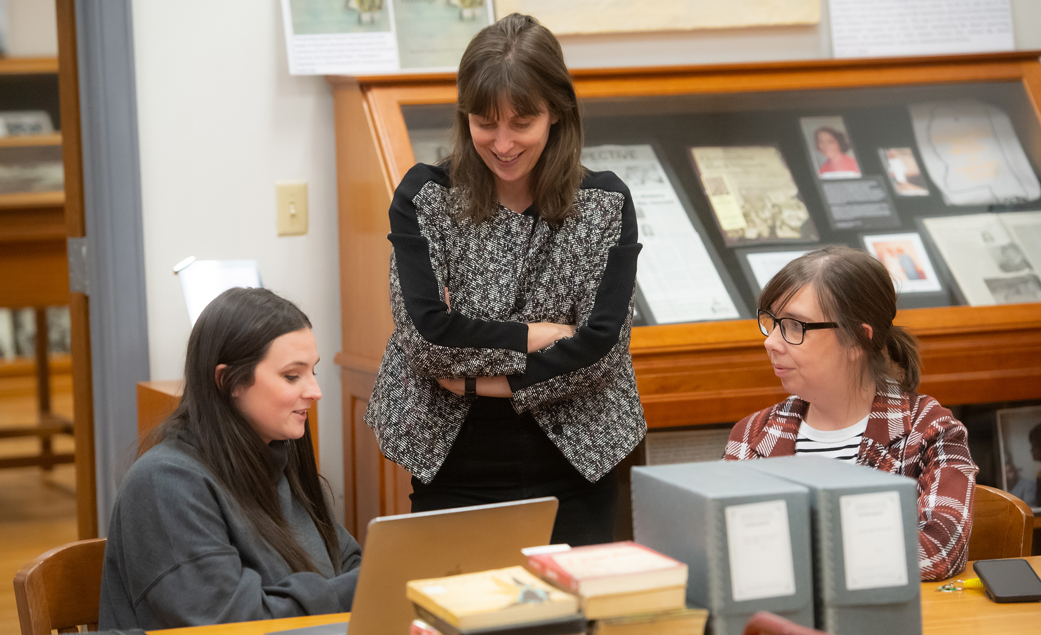 Eva Payne (center), UM associate professor of history, speaks with Madeline Burdine (left), a first-year graduate sociology and anthropology student, and Angie Rankin, a second-year sociology graduate student, about their display for the Queer Mississippi Exhibit in the Department of Archives and Special Collections in the J.D. Williams Library. The exhibit uses university archival materials and quotes from the Queer Mississippi Oral History project to show the history of LGBTQ+ people in the state. Photo by Kevin Bain/Ole Miss Digital Imaging Services