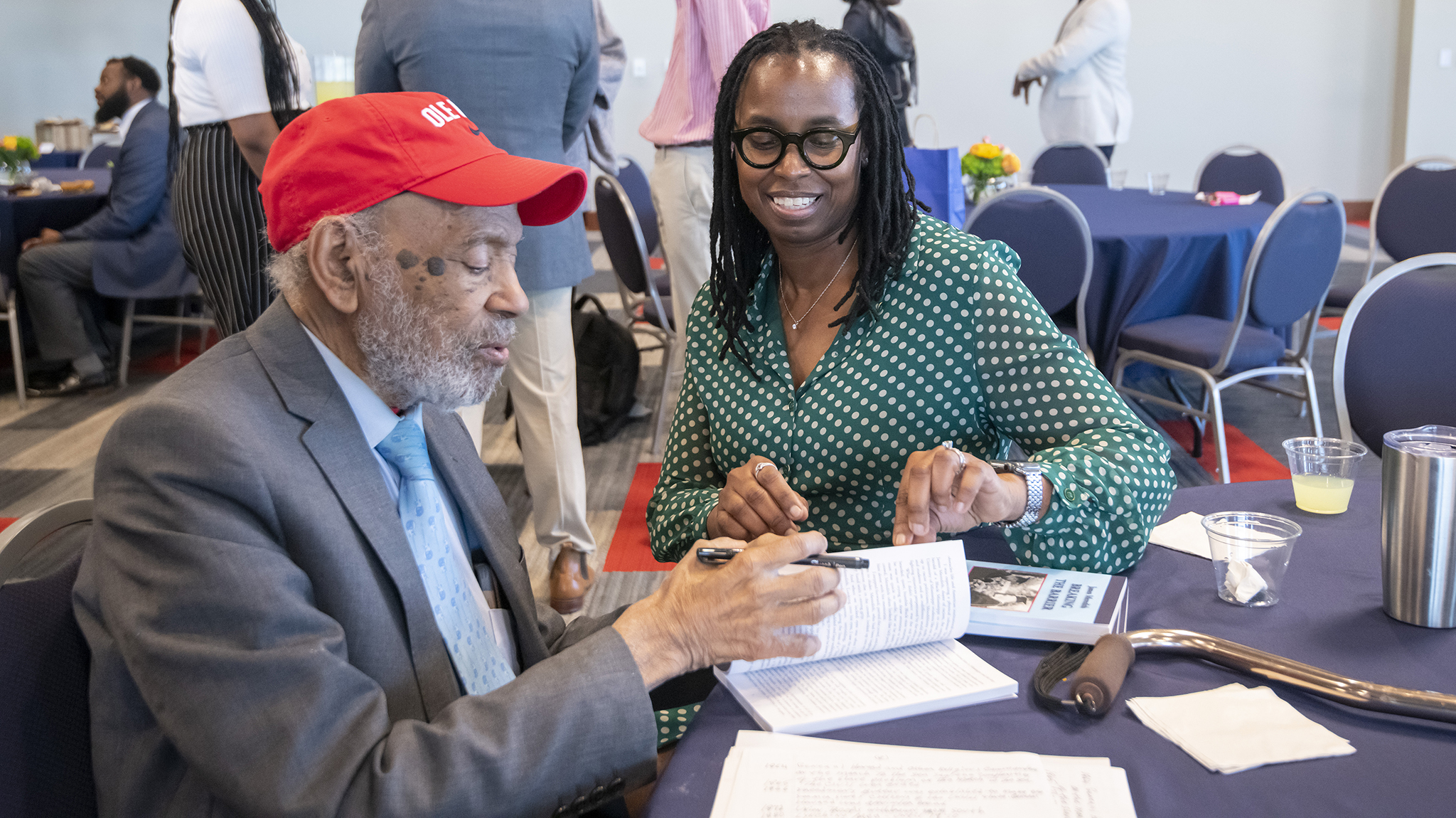 James Meredith (left), who enrolled as the university’s first Black student in 1962, signs a copy of ‘James Meredith: Breaking the Barrier’ following the Honoring Diversity Excellence ceremony, a final event of the 60th anniversary of integration commemoration. The ceremony in the Ole Miss Student Union Ballroom honored faculty and staff achievements in diversity and inclusion. Photo by Srijita Chattopadhyay/Ole Miss Digital Imaging Services