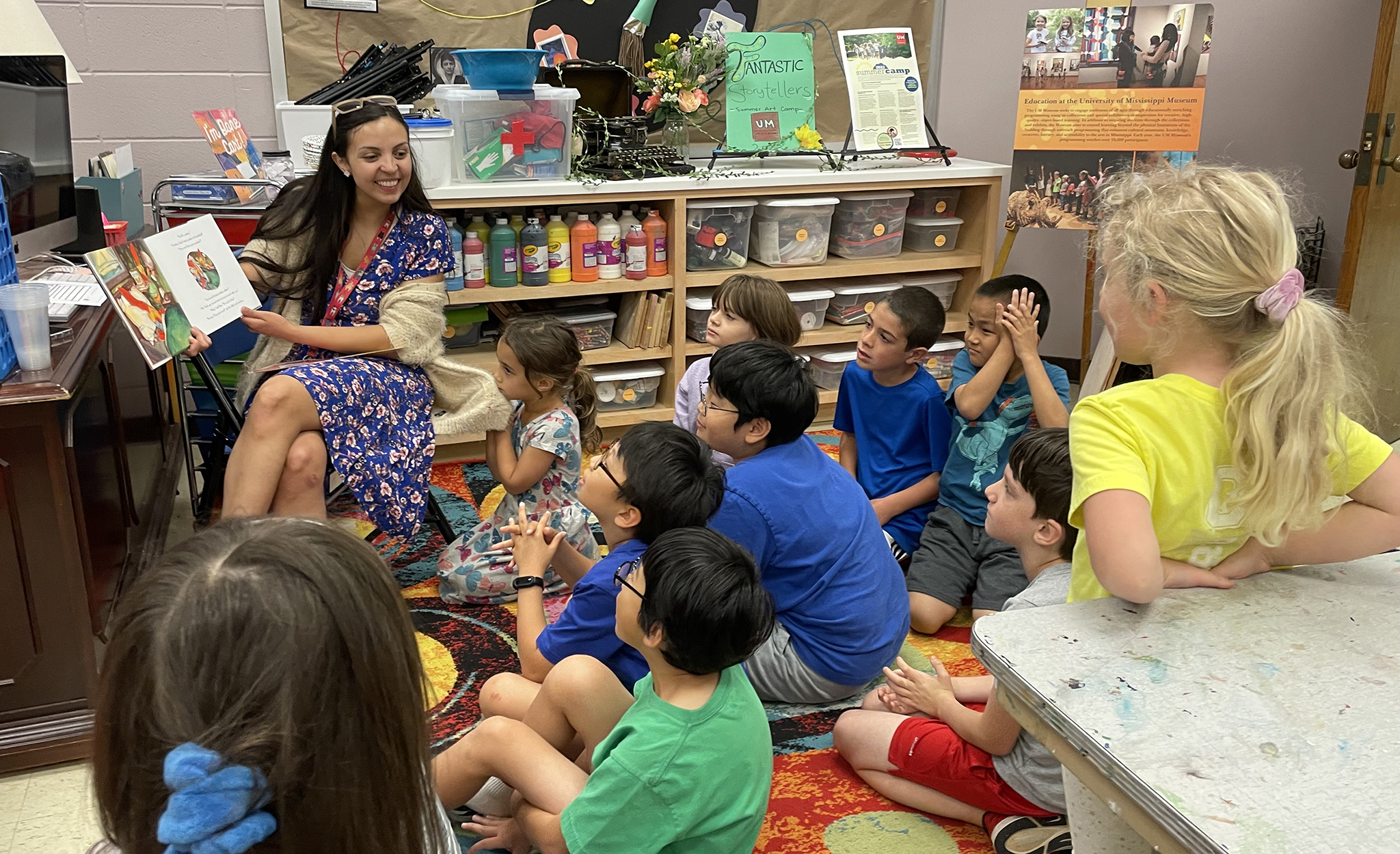 Rosa Salas Gonzalez (left), museum educator at the University of Mississippi Museum, reads to students during the recent Fantastic Storytellers camp, in which children grades 1-5 learned how to tell and illustrate a compelling story. The museum is offering several more camps throughout the summer. Submitted photo