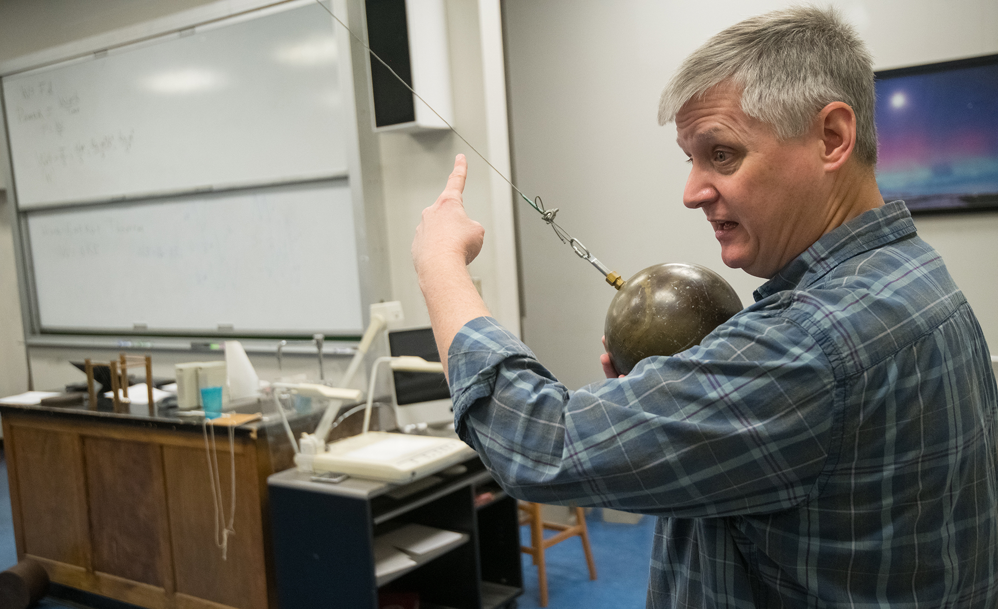 Breese Quinn, professor of physics and director of the university’s Multimessenger Astrophysics Center, demonstrates laws of physics to students in his classroom. For the last decade, Quinn and fellow UM researchers have been working with an international group at Fermilab, where a new measurement of the movement of subatomic particles could change the way physicists understand the universe. Photo by Kevin Bain/Ole Miss Digital Imaging Services